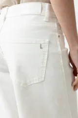 Pantalón de jean blanco, tiro alto, de corte ancho (wide leg) y largo.