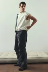 Pantalón cargo de algodón, color negro lavado, con corte holgado y cordón ajustable en cintura y tobillos. Presenta bolsillos cargo grandes en las piernas con solapas y pliegues cosidos en las rodillas.