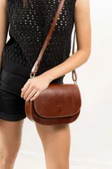 Cartera bandolera marrón de cuero natural con estructura rígida, forro interior de tela, bolsillo interno con cierre y terminaciones impecables.