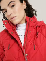 Campera acolchada roja con capucha, cierre de cremallera, bolsillos laterales con cremallera y logo bordado en la manga.