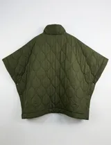 Poncho acolchado color mostaza con cuello alto y abertura frontal con cierre. Presenta un patrón capitoné de formas ovaladas y bolsillos delanteros.