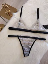 Conjunto de lencería color tostado con detalles en negro, compuesto por un corpiño triangular de encaje con breteles finos y una tanga de encaje con tiras laterales ajustables.