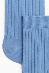 Medias de vestir celestes con textura acanalada y borde superior elástico.