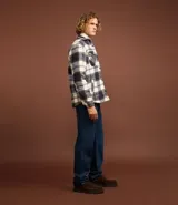 Campera trucker masculina de franela a cuadros en tonos blanco, negro y gris, con cuello inglés, abotonado delantero, bolsillos con solapa en el pecho y bolsillos laterales. Interior forrado en sherpa.