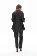 Camisa negra de algodón con corte recto, terminaciones cuidadas en los puños y botones ocultos.