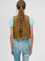 Chaleco marrón de denim con apliques metálicos y flecos en el ruedo.