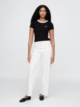 Remera negra de algodón con cuello redondo blanco y logo de Gap bordado en el pecho.