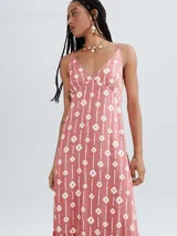 Vestido largo rosado con estampado de líneas y figuras geométricas blancas, escote en V y breteles finos.