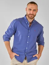 Camisa celeste de lino con cuello abotonado, manga larga con puños abotonados y bolsillo en el pecho.