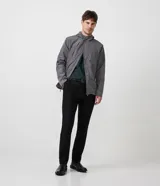 Campera gris de poliéster con capucha, cierre frontal con cremallera y botones a presión.