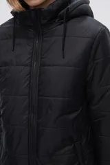 Campera puffer gris con capucha forrada en piel sintética negra, cierre frontal con cremallera negra y bolsillos laterales.