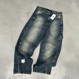 Pantalón de jean oversize estilo baggy con teñido acid y estampado de sol en blanco.
