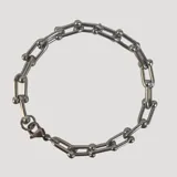 Pulsera plateada de acero con eslabones tipo cadena y cierre de mosquetón.