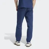 Pantalón de jogging azul marino de felpa, con corte ajustado, cintura elástica con cordón, bolsillos laterales y puños acanalados. Logo del trifolio bordado en blanco en la pierna izquierda.