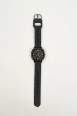 Reloj de pulsera negro con caja cuadrada y correa de silicona con hebilla.