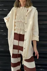 Camisa color crema de lino con cuello clásico, manga larga y corte holgado.