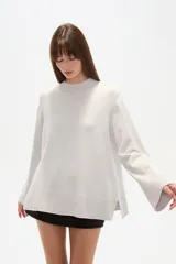 Sweater de viscosa color beige, con cuello polera, corte holgado y pespuntes decorativos en el frente.