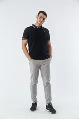 Pantalón chino negro elastizado, corte slim, con bolsillos y cremallera.