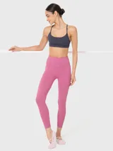 Top deportivo gris de soporte bajo, ideal para pilates y yoga. Tiene escote redondo, tirantes finos ajustables que se cruzan en la espalda y almohadillas removibles.