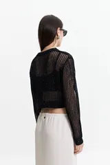 Sweater negro de tejido calado con escote redondo y mangas largas.