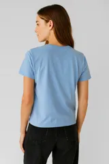 Remera color crema de algodón con cuello redondo y estampado con la frase "In my inner peace era" en letras negras.