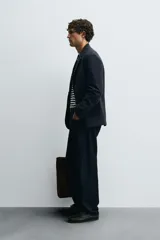 Blazer regular fit color azul marino, con cuello con solapas de muesca, manga larga con puño abotonado y bolsillos de solapa en la cadera. Incluye bolsillo interior y abertura en el centro de la espalda. Cierre frontal de botonadura simple.