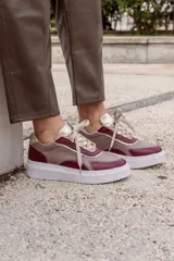 Championes urbanos de cuero color beige y bordó con detalles dorados.