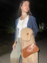 Ruana de lana merino en color champagne, con diseño de tejido de punto y terminación de flecos en el ruedo. Prenda de estilo bohemio y atemporal.