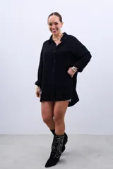 Camisa negra de corte oversize con cuello clásico y cierre frontal con botones.