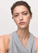 Top sin mangas de tejido de punto fino con lúrex, color gris claro, con cuello drapeado tipo cascada y diseño entallado.