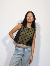 Remera corta de tafeta color verde militar con lunares de terciopelo negros, corte a la base y botón en la parte trasera.