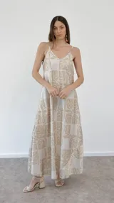 Vestido largo de tirantes finos con estampado de hojas en tonos beige y blanco.