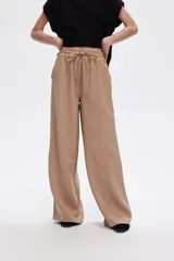 Pantalón de viscosa color beige, de corte ancho y tiro alto.