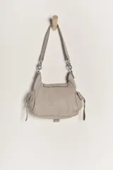 Bolso mini de cuero desgastado color beige claro, con cierre magnético plegable, monedero forrado y bolsillos interiores. Incluye correa de hombro extrapole.