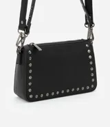Bandolera negra de cuero sintético con correa larga ajustable y cierre de cremallera. Decorada con tachas metálicas plateadas.