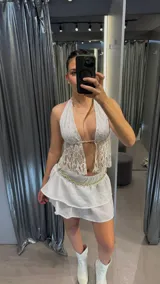 Top blanco de encaje con escote halter y espalda descubierta.