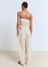 Top strapless color crudo, con frunces laterales y diseño asimétrico.