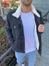 Chaqueta de jean negra con forro de corderito blanco en el interior y cuello.