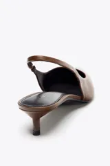 Zapato destalonado de cuero color marrón, con tacón kitten y tira trasera con pieza elástica ajustable.