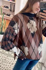 Sweater de punto con cuello redondo y estampado de rombos y flores en tonos violeta, marrón y rojo.