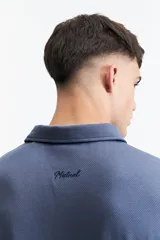 Remera polo negra con bolsillo de nylon en el pecho y logo bordado. Corte regular.