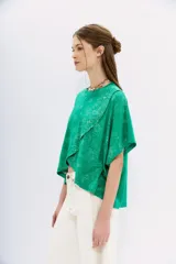 Remera lila con estampado de cachemir, de mangas cortas y cuello redondo. Tiene calce amplio y corte cruzado al frente.
