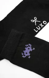 Medias negras con diseño de un alienígena de videojuego en color lila.