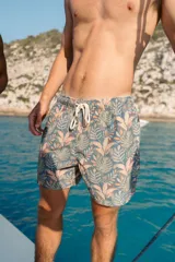 Short de baño azul con estampado de hojas en tonos verde y naranja. Cuenta con elástico en la cintura, cordón ajustable, tres bolsillos y mesh interior hipoalergénico.