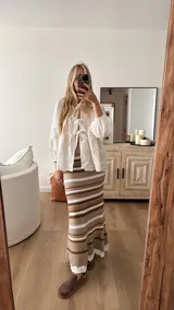 Pollera midi tejida a rayas horizontales en tonos beige, naranja, fucsia y gris.