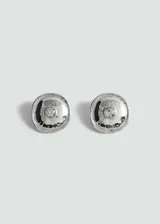 Par de aros plateados con forma redondeada y cristal facetado en el centro.