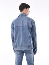 Campera de jean negra con cuello clásico, cierre frontal con botones metálicos, bolsillos con solapa en el pecho y corte recto.