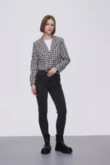 Blazer corto con estampado a cuadros blancos y negros, solapas y cierre con dos botones.