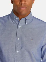 Camisa de vestir celeste con microestampado, de corte regular, cuello abotonado y manga larga. Incluye logo de Tommy Hilfiger bordado en el pecho.