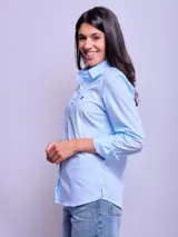 Camisa entallada de manga larga color rosa claro, con cuello clásico y cierre frontal con botones.